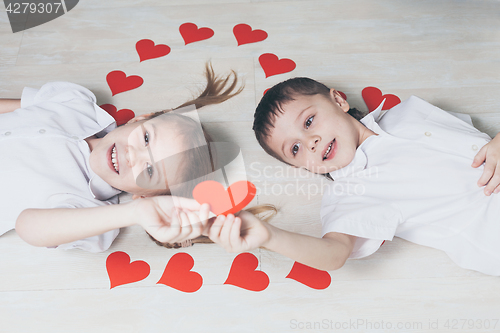 Image of little boy and girl lying on the floor.