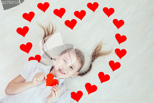 Image of One little girl lying on the floor.