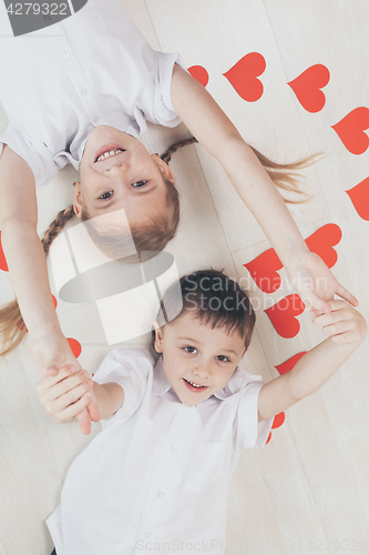 Image of little boy and girl lying on the floor.