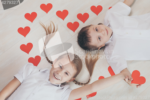 Image of little boy and girl lying on the floor.