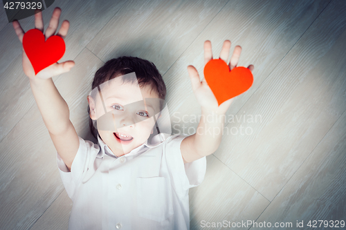 Image of One little boy lying on the floor.