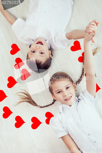 Image of little boy and girl lying on the floor.