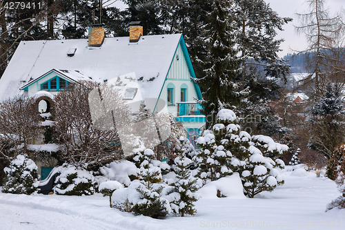 Image of beautiful house in winter garden covered by snow