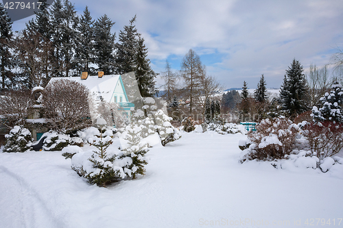 Image of beautiful house in winter garden covered by snow