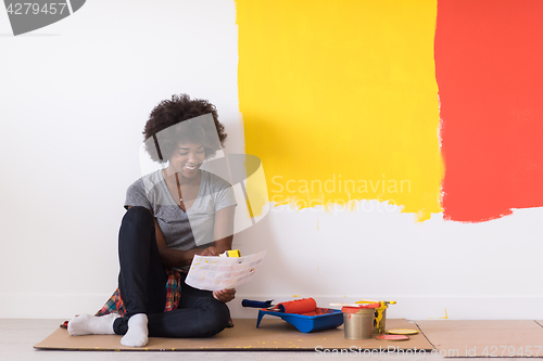 Image of back female painter sitting on floor