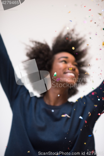 Image of African American woman blowing confetti in the air