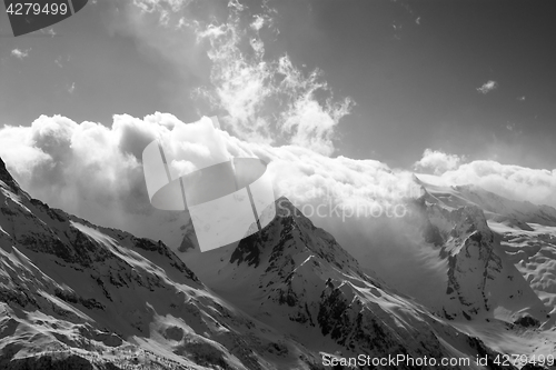 Image of Black and white view on snow sunlight mountains in clouds