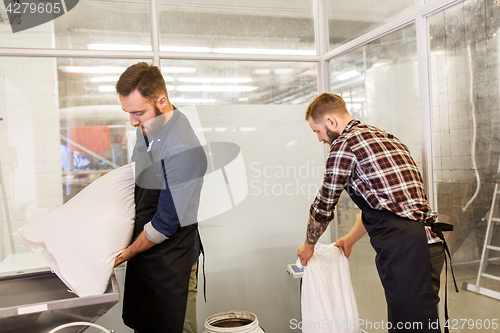 Image of men with malt bags and mill at craft beer brewery