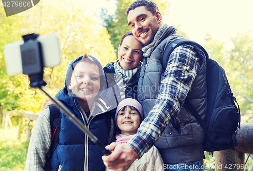 Image of family with backpacks taking selfie and hiking