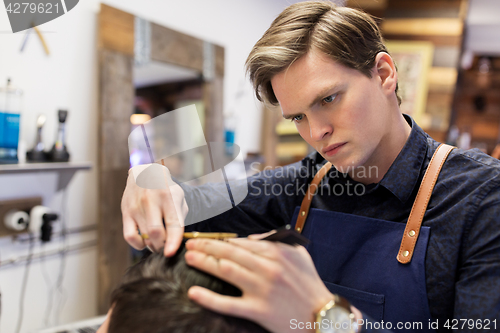 Image of man and barber cutting hair at barbershop