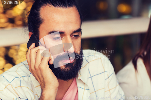 Image of sad man calling on smartphone at restaurant
