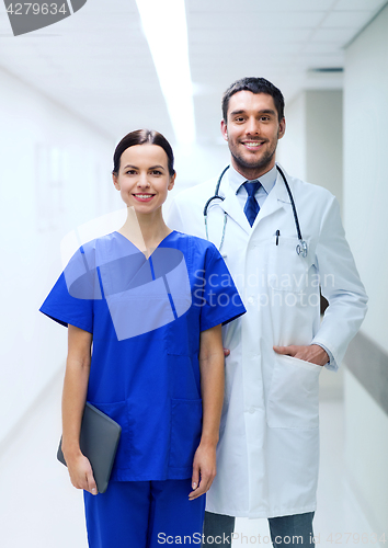 Image of smiling doctor in white coat and nurse at hospital