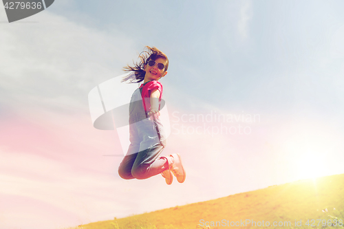 Image of happy little girl jumping high outdoors