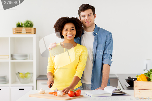 Image of happy couple cooking food at home kitchen