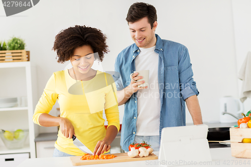 Image of happy couple cooking food at home kitchen