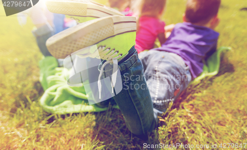 Image of close up of kids lying on picnic blanket outdoors