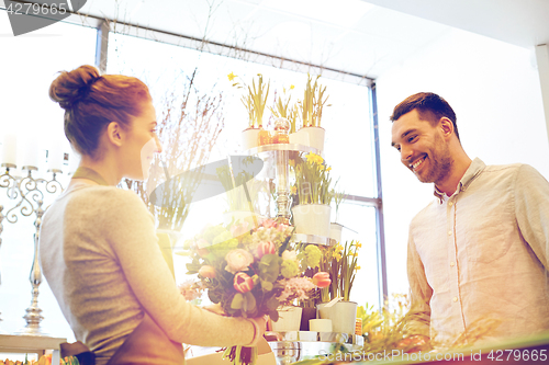 Image of smiling florist woman and man at flower shop