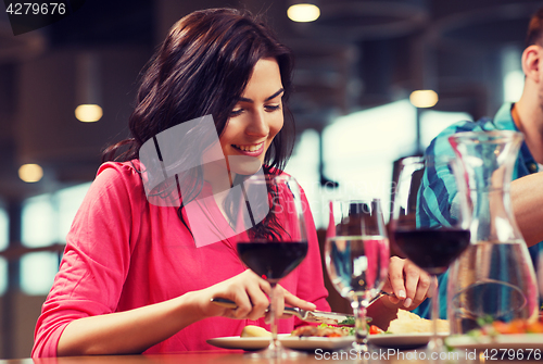 Image of happy woman having dinner at restaurant