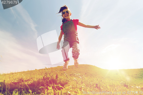 Image of happy little girl jumping high outdoors