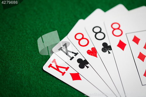 Image of poker hand of playing cards on green casino cloth