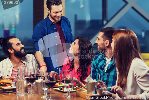 Image of friends dining and drinking wine at restaurant