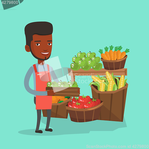 Image of Supermarket worker with box full of apples.