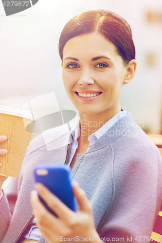 Image of smiling woman with coffee and smartphone