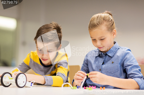 Image of happy children building robots at robotics school