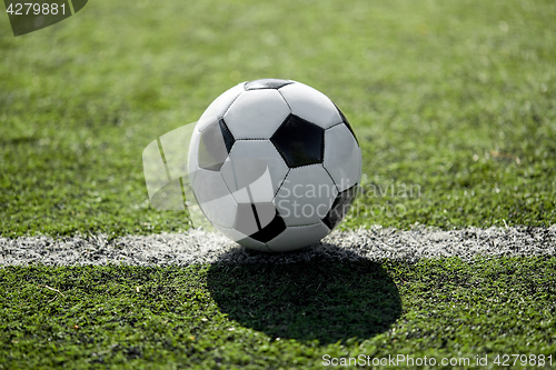 Image of soccer ball on football field marking line