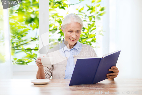 Image of happy smiling senior woman reading book at home