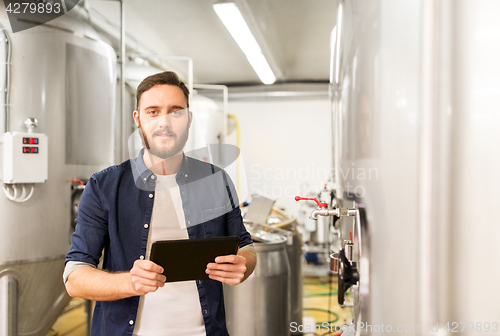 Image of man with tablet pc at craft brewery or beer plant