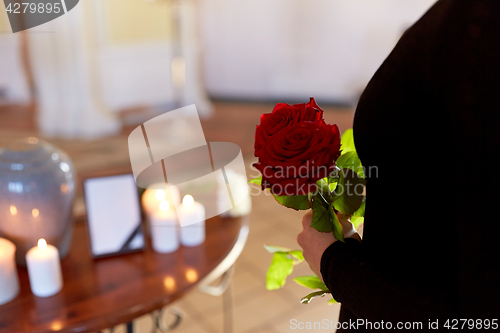 Image of woman with roses and cremation urn at funeral