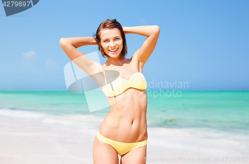 Image of happy woman in bikini posing on summer beach