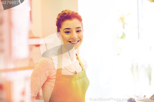 Image of smiling florist woman or gardener at flower shop