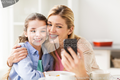 Image of happy family taking selfie by smartphone at home