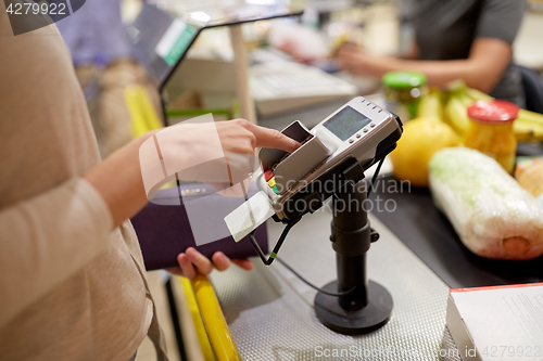 Image of woman entering pin code at store cash register