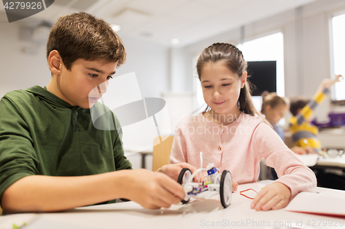 Image of happy children building robots at robotics school