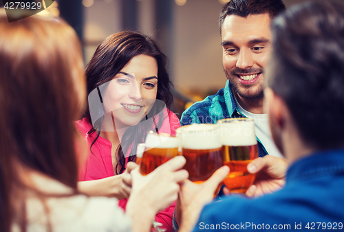 Image of friends drinking beer and clinking glasses at pub
