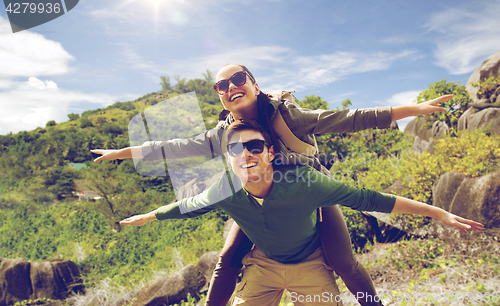 Image of happy couple with backpacks having fun outdoors