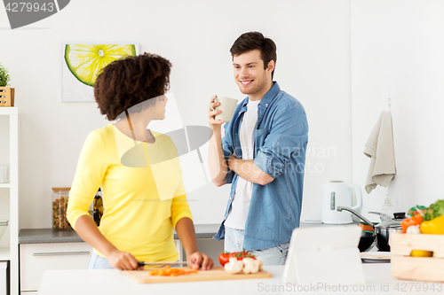 Image of happy couple cooking food at home kitchen