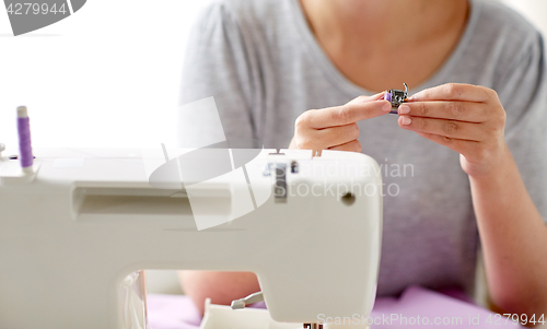 Image of tailor woman with spool of sewing machine