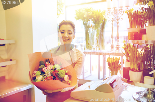 Image of smiling florist woman with bunch at flower shop