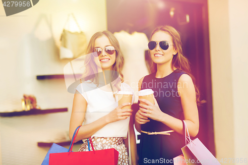 Image of young women with shopping bags and coffee at shop