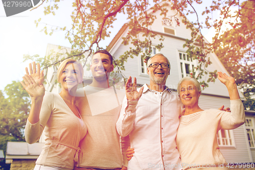 Image of happy family in front of house outdoors