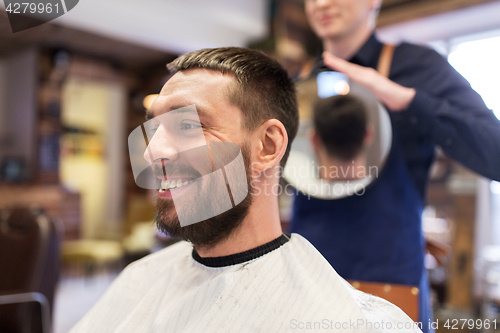 Image of man and hairdresser with mirror at barbershop