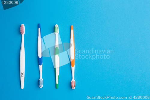 Image of Multi-colored toothbrushes on blue background