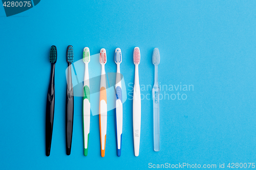 Image of Multi-colored toothbrushes on blue background