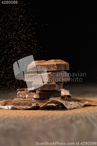 Image of Broken chocolate on wooden table