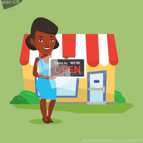 Image of Female shop owner holding open signboard.