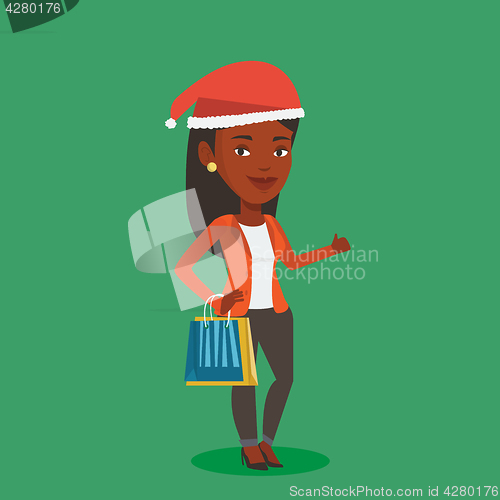 Image of Woman in santa hat shopping for christmas gifts.